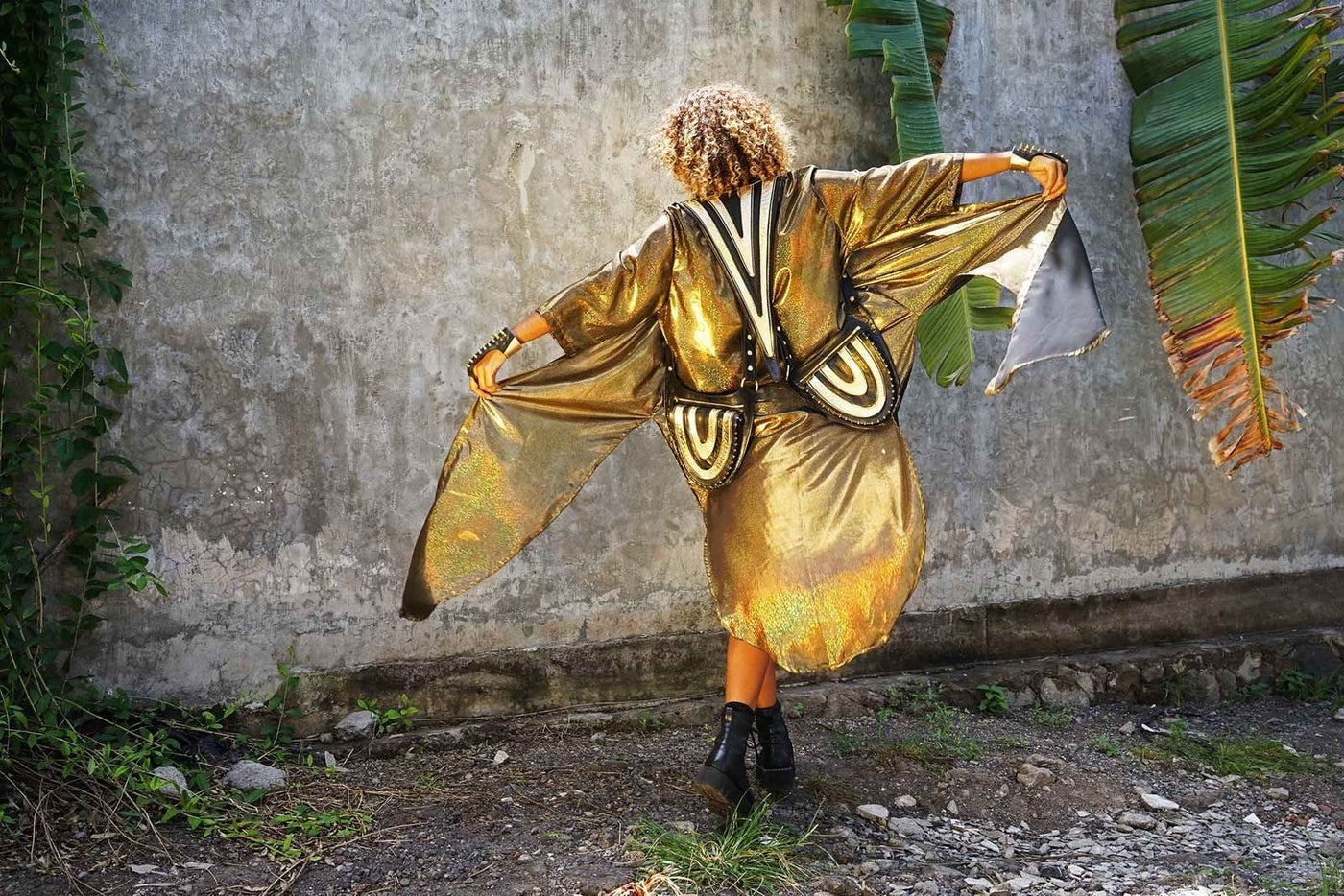 a dancing woman wearing a black and gold leather festival bag from Love Khaos