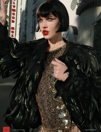 woman wearing black feather jacket and gold sequin dress from Love Khaos avant garde fashion brand.