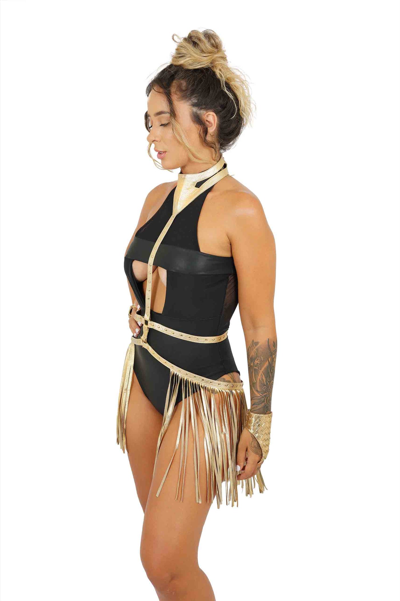 Woman wearing a gold Leather Body Harness with tassel belt skirt from Love Khaos.