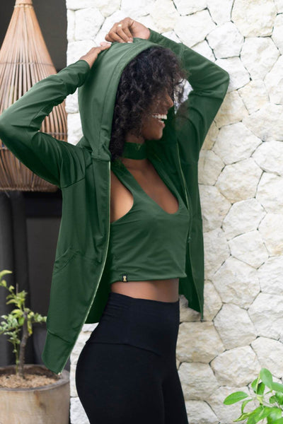 High neck crop top in evergreen, worn with matching evergreen hoodie and black high waisted leggings made from eco friendly recycled plastic fabric by Ekoluxe sustainable loungewear brand