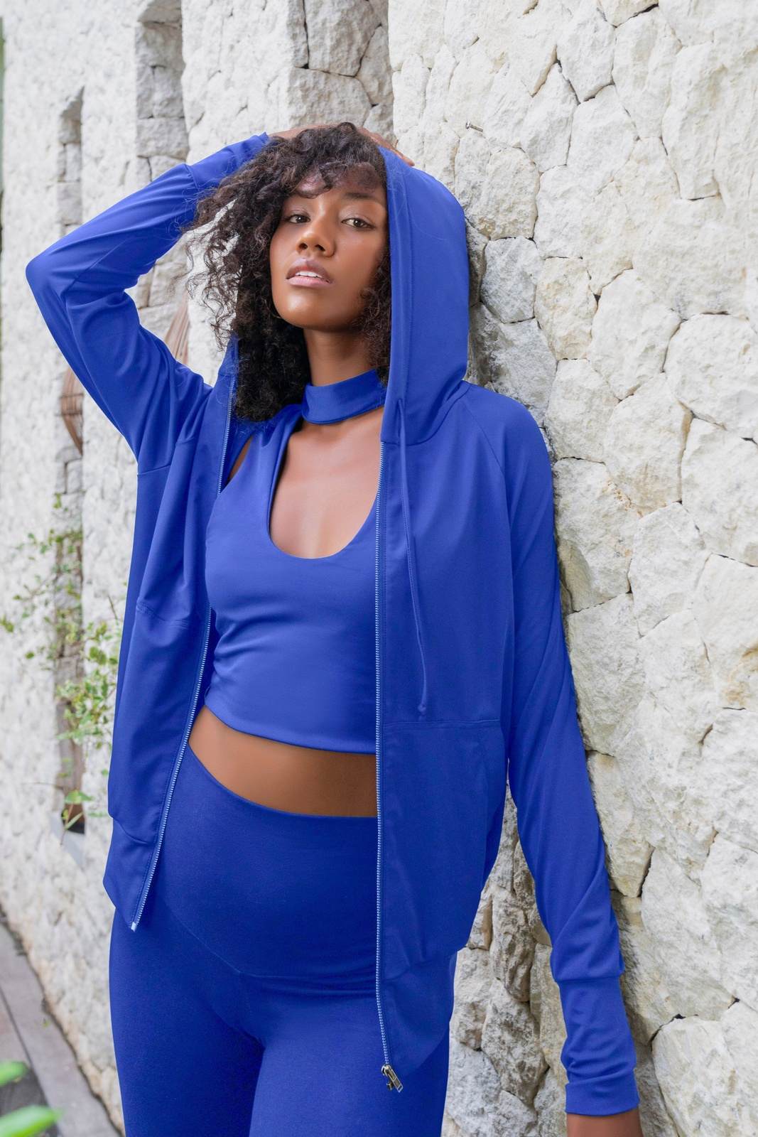Mock neck crop top in cobalt blue and matching colored high waisted leggings and hoodie, a complete outfit set made from eco friendly recycled plastic fabric by Ekoluxe sustainable loungewear brand