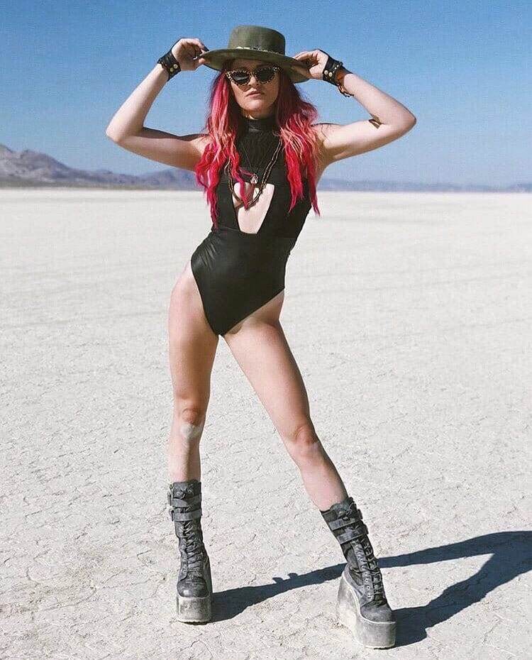 Woman at burning man wearing a black underboob bodysuit for raves from Love Khaos festival clothing brand.