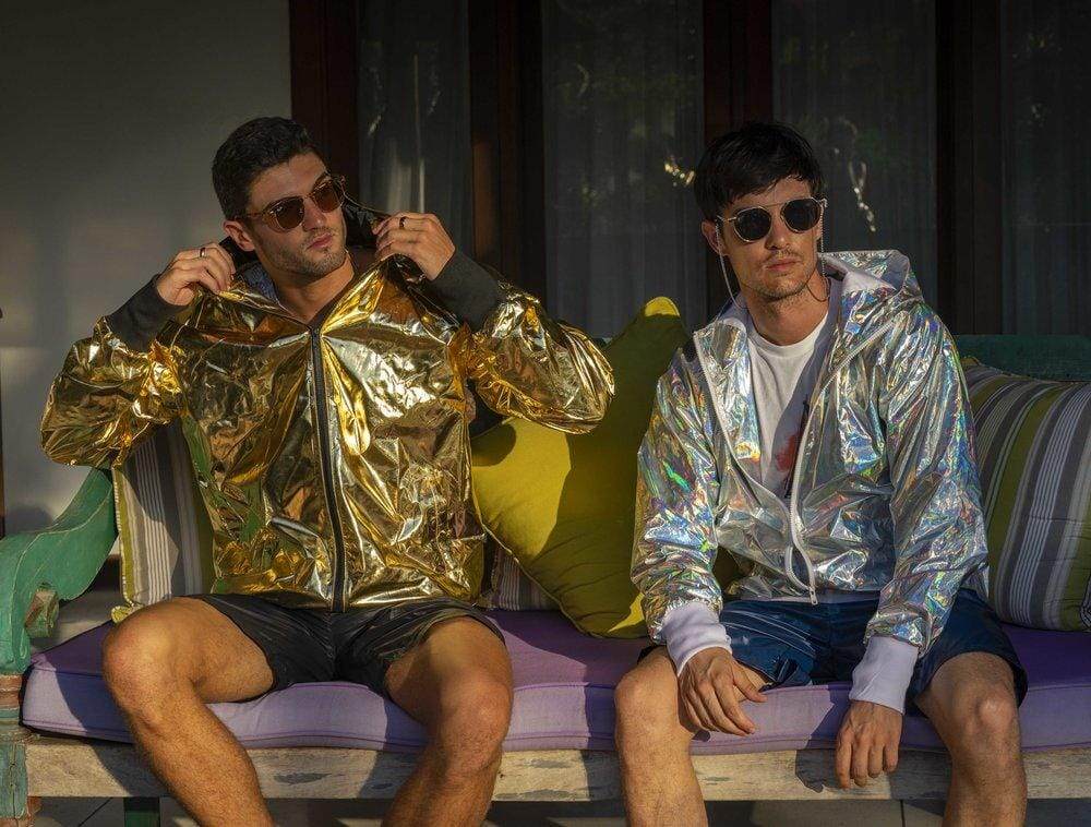 Man wearing a gold jacket and man wearing a holographic jacket from Love Khaos streetwear brand